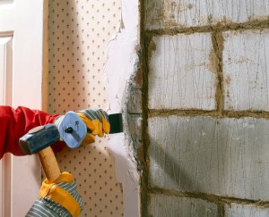 Person in construction gear removes drywall