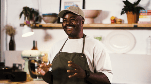 Chef Dom Taylor, master of Anglo-Caribbean cuisine, smiling in the kitchen.